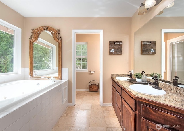 bathroom with baseboards, a whirlpool tub, a sink, and double vanity