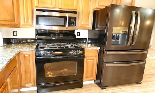 5036 Beach Way NE, Olympia, WA 98516 - kitchen with stainless steel appliances, light stone counters, light wood-style flooring, and brown cabinetry