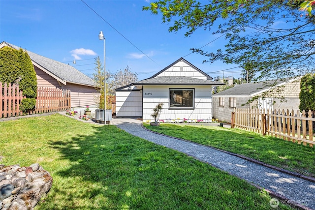 view of front of home featuring fence and a front lawn