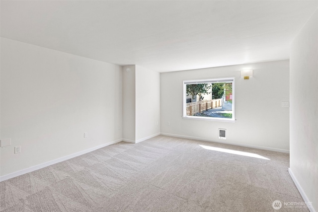 carpeted empty room with visible vents and baseboards