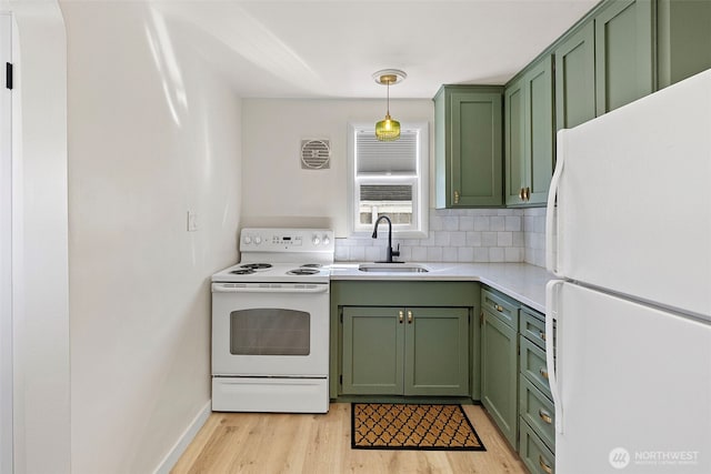 kitchen with a sink, green cabinetry, white appliances, and light countertops