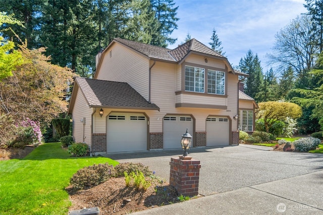 view of front of property featuring brick siding, driveway, a front lawn, and a garage