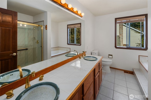 full bathroom featuring toilet, a sink, double vanity, and a stall shower