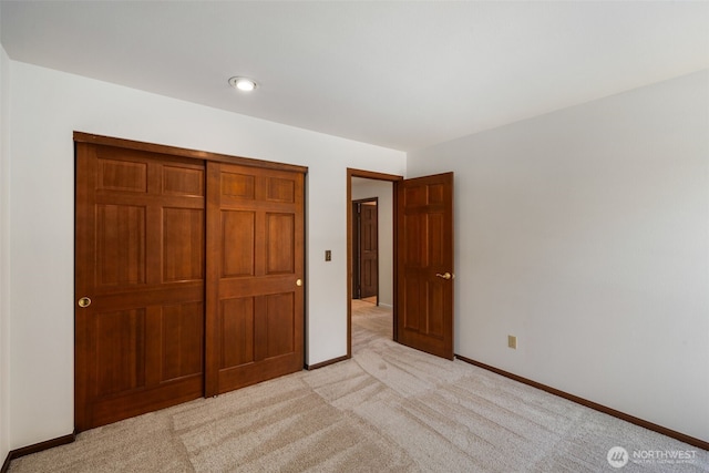 unfurnished bedroom featuring light colored carpet and baseboards