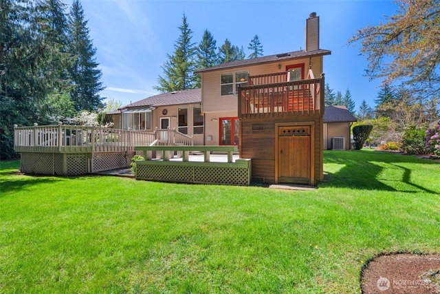 back of property with a lawn, a chimney, a wooden deck, and cooling unit