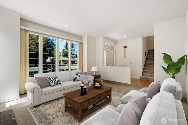 living area featuring baseboards, stairs, and recessed lighting