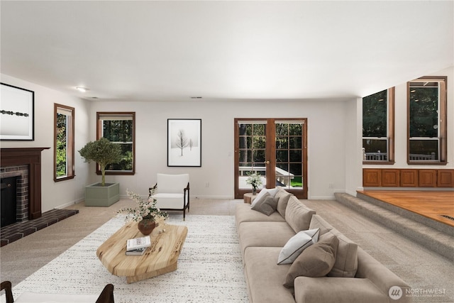 carpeted living area featuring baseboards and a fireplace
