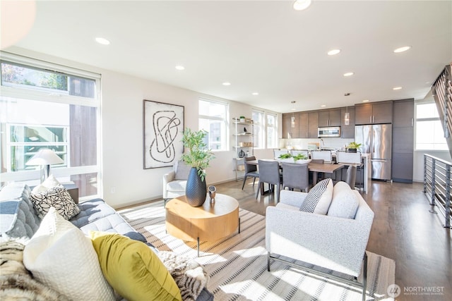 living room with light wood-style floors, recessed lighting, and baseboards
