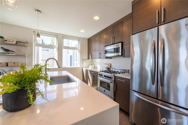 kitchen featuring a sink, appliances with stainless steel finishes, decorative backsplash, light countertops, and dark brown cabinets