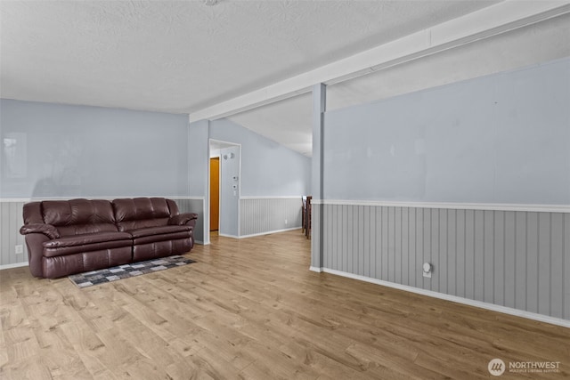 11519 21st Ave E Unit 84, Tacoma, WA 98445 - living room with vaulted ceiling with beams, wainscoting, a textured ceiling, and wood finished floors