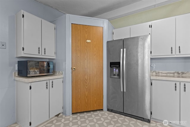11519 21st Ave E Unit 84, Tacoma, WA 98445 - kitchen with white cabinetry, light floors, light countertops, and stainless steel appliances