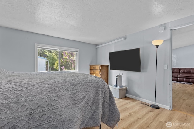 11519 21st Ave E Unit 84, Tacoma, WA 98445 - bedroom with a textured ceiling, visible vents, and wood finished floors