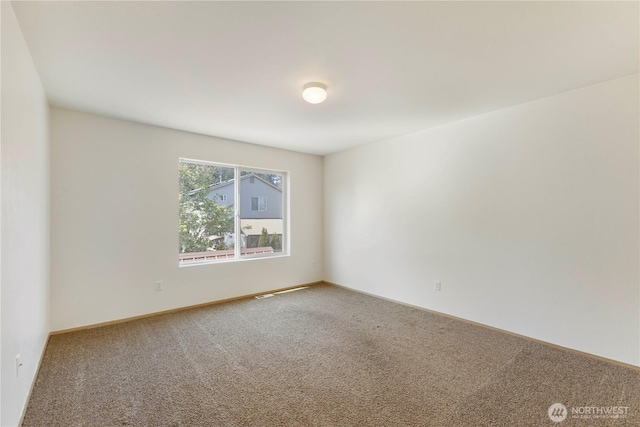 carpeted empty room with baseboards