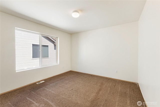 carpeted spare room with baseboards and visible vents