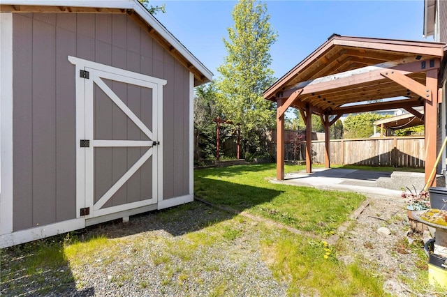 view of yard featuring a fenced backyard, an outbuilding, a patio area, and a shed