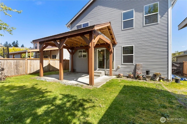 back of property with a patio area, a lawn, and fence