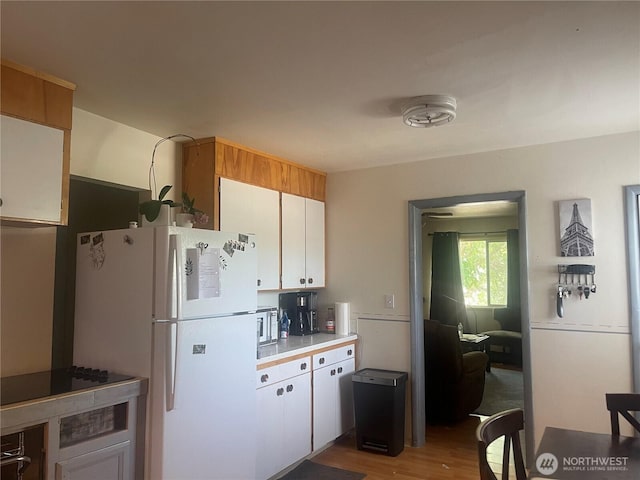 409 N Franklin Ave, Wenatchee, WA 98801 - kitchen featuring freestanding refrigerator, wood finished floors, light countertops, and white cabinets