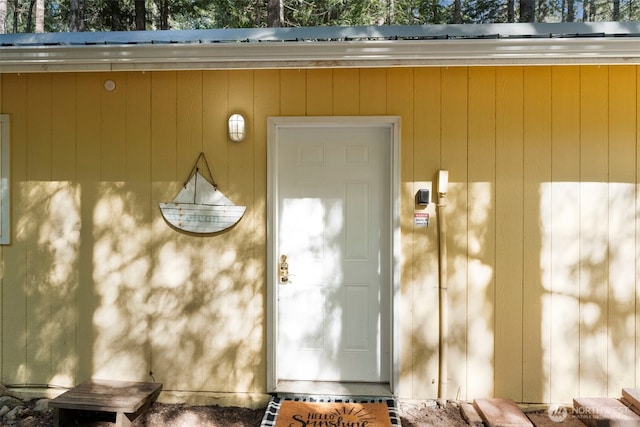 doorway to property featuring metal roof