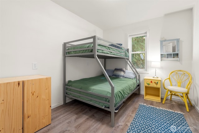 bedroom with baseboards and wood finished floors