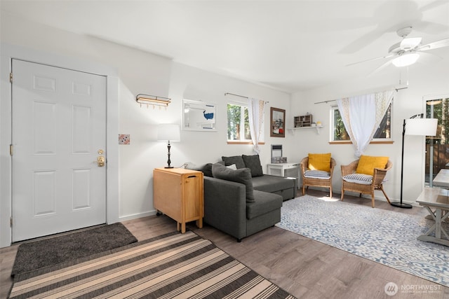 living room with wood finished floors, baseboards, and ceiling fan