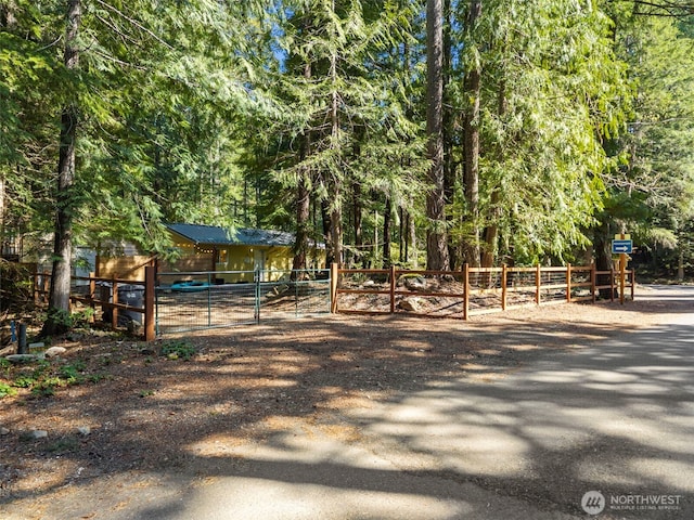 view of yard featuring fence and a wooded view