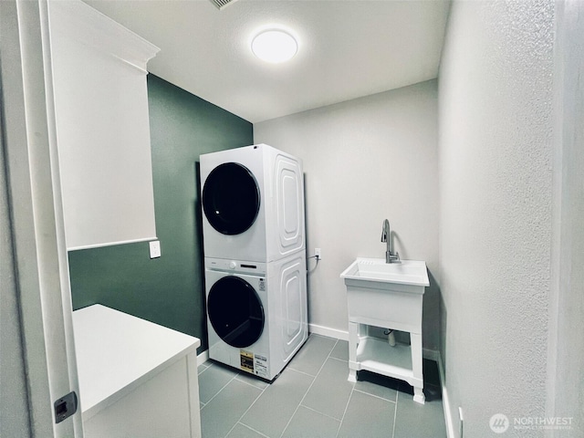 18126 SE 246th St, Covington, WA 98042 - washroom featuring baseboards, tile patterned floors, stacked washing maching and dryer, and laundry area