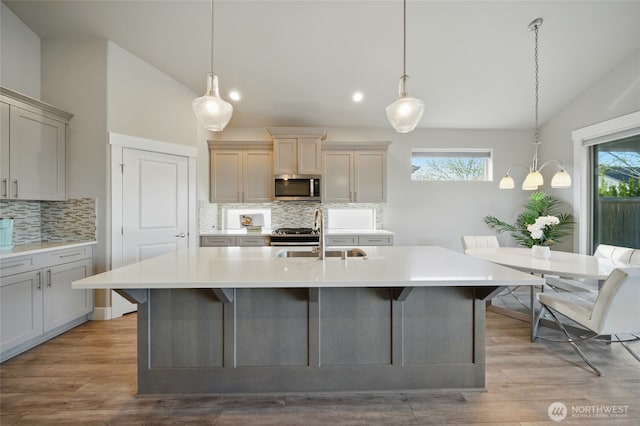 308 Chardonnay Ct, Walla Walla, WA 99362 - kitchen featuring stainless steel appliances, light countertops, vaulted ceiling, a sink, and tasteful backsplash