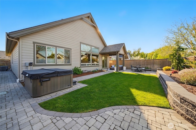 308 Chardonnay Ct, Walla Walla, WA 99362 - back of house featuring a fenced backyard, central AC, a patio, a lawn, and a hot tub