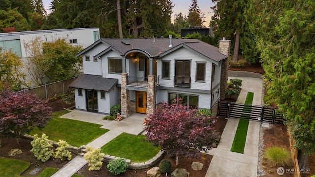 4229 95th Ave NE, Yarrow Point, WA 98004 - view of front of home featuring a balcony, a chimney, fence, a front yard, and roof with shingles