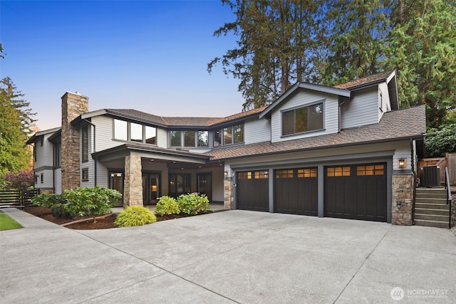 4229 95th Ave NE, Yarrow Point, WA 98004 - view of front of house featuring driveway, stone siding, a chimney, fence, and an attached garage
