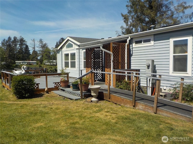 rear view of house featuring a deck and a lawn