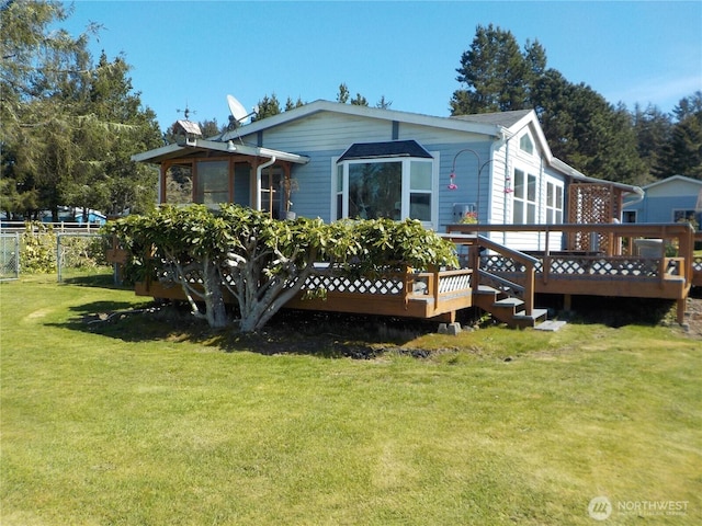 back of house with a lawn, fence, and a wooden deck