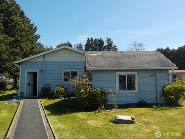 view of front of house with a shingled roof and a front yard