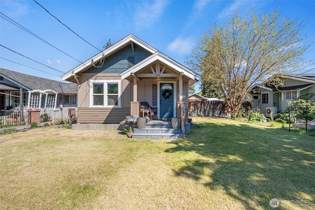 bungalow-style house featuring a front lawn and fence