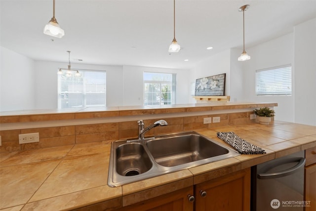 10757 NE Red Wing Way Unit 201, Hillsboro, OR 97006 - kitchen with stainless steel dishwasher, decorative light fixtures, brown cabinetry, and tile countertops