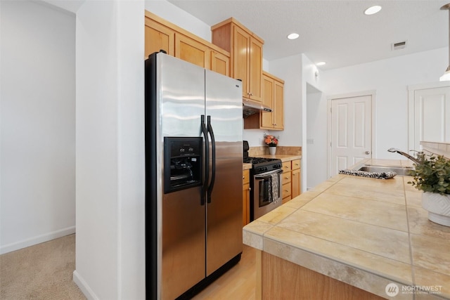 10757 NE Red Wing Way Unit 201, Hillsboro, OR 97006 - kitchen featuring stainless steel appliances, under cabinet range hood, light brown cabinets, tile countertops, and recessed lighting