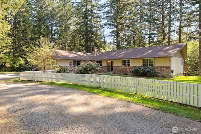 view of home's exterior featuring a fenced front yard, a chimney, and brick siding