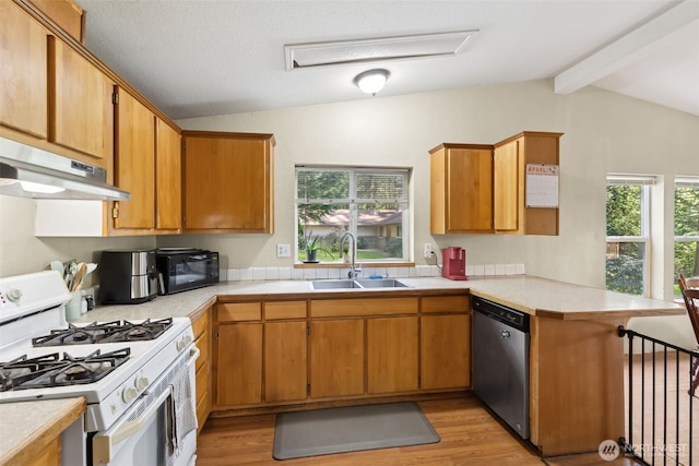 kitchen featuring white gas stove, stainless steel dishwasher, a sink, a peninsula, and under cabinet range hood