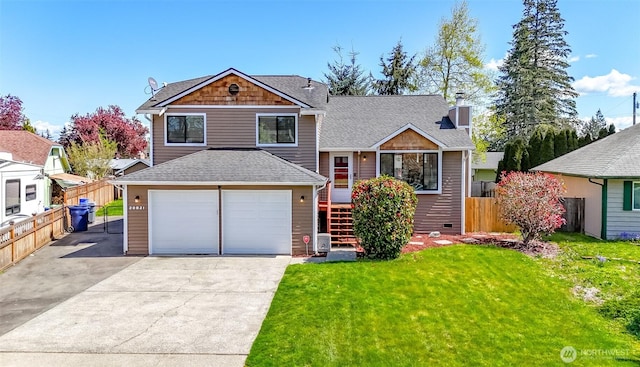 split level home with roof with shingles, driveway, fence, a garage, and a front yard