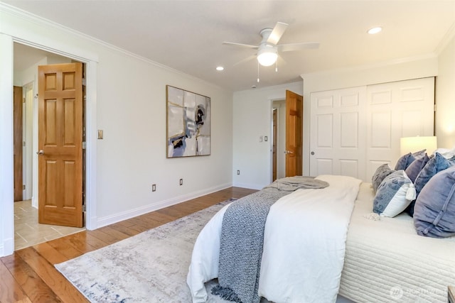 bedroom with baseboards, wood finished floors, recessed lighting, and crown molding