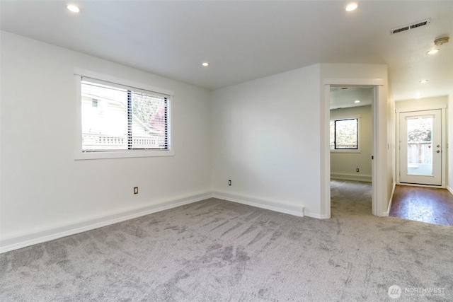 carpeted spare room featuring recessed lighting, visible vents, and baseboards
