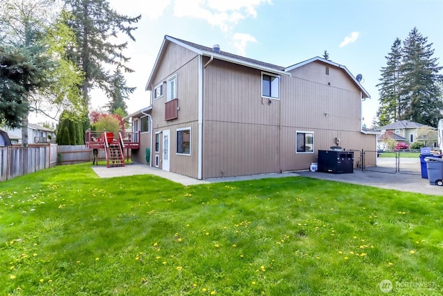 rear view of property with a gate, a yard, a fenced backyard, and stairs