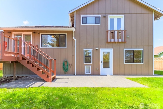 back of house featuring stairway, a yard, a patio, and a deck