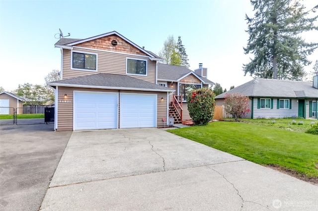 tri-level home featuring stairway, fence, an attached garage, driveway, and a front yard