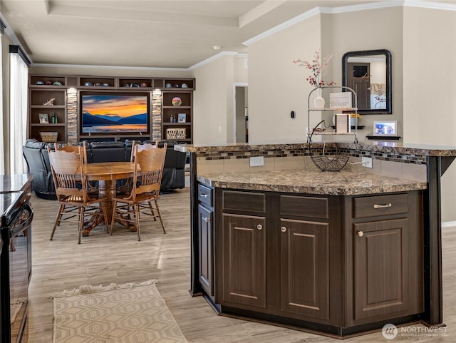 kitchen with black range with electric cooktop, light wood-type flooring, dark brown cabinets, crown molding, and light stone countertops
