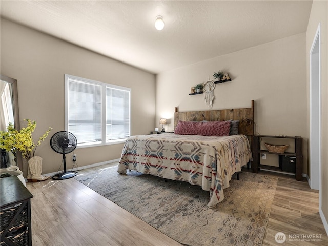 bedroom featuring baseboards and wood finished floors