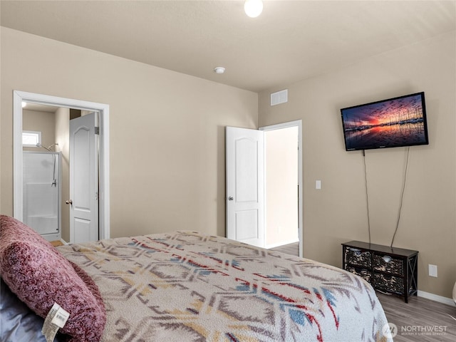bedroom with wood finished floors, visible vents, and baseboards