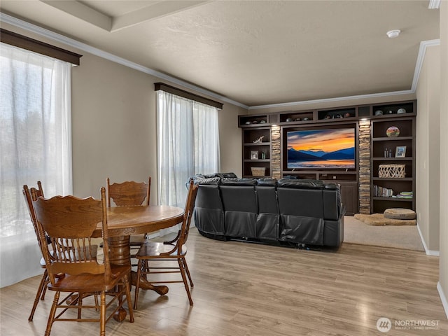 dining area featuring a healthy amount of sunlight, light wood-style floors, and crown molding