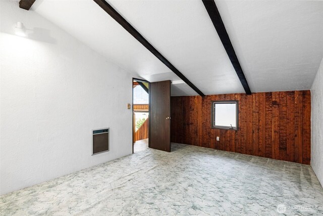 bonus room featuring heating unit, carpet flooring, healthy amount of natural light, and wooden walls