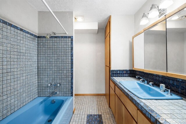 full bathroom featuring tile patterned flooring, shower / bath combination, vanity, a textured ceiling, and baseboards